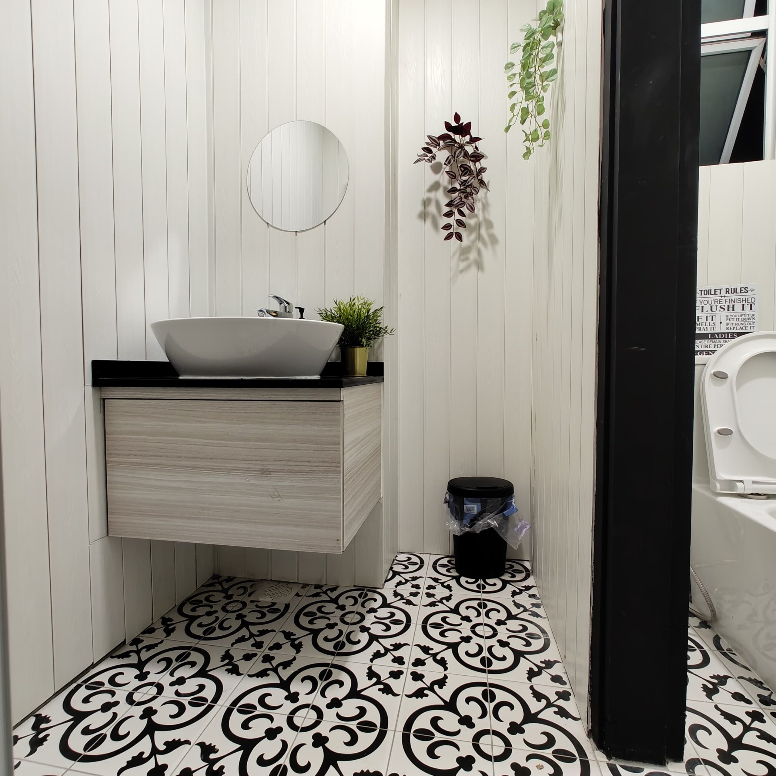 Bathroom with white vertical panel walls, Peranakan-style black and white floor tiles and floating timber vanity