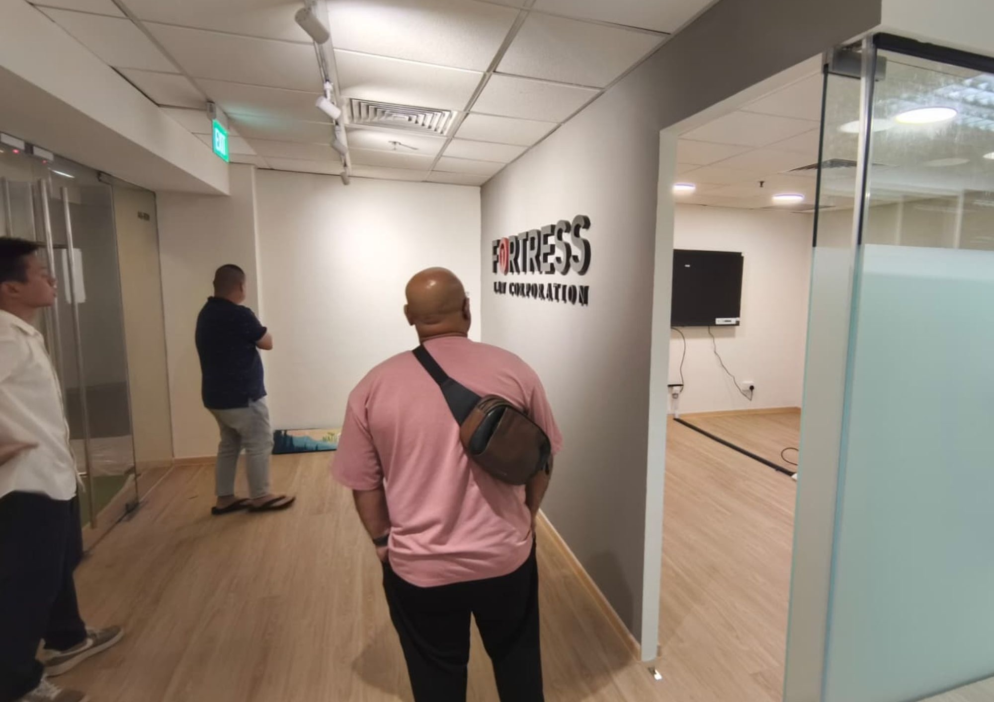 Corridor with signage and glass partitions at Fortress Law Corporation