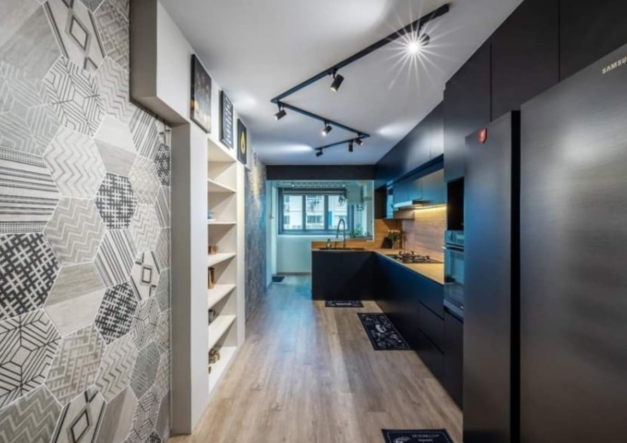 Kitchen wide view from dark countertop showing patterned tiles and industrial wall lamp