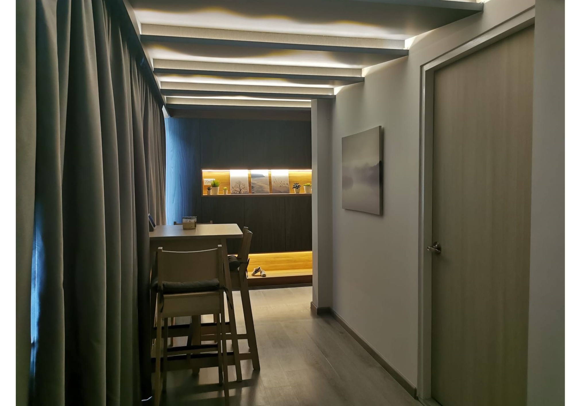Dining area with dark grey walls, dining table and yellow accent cabinet